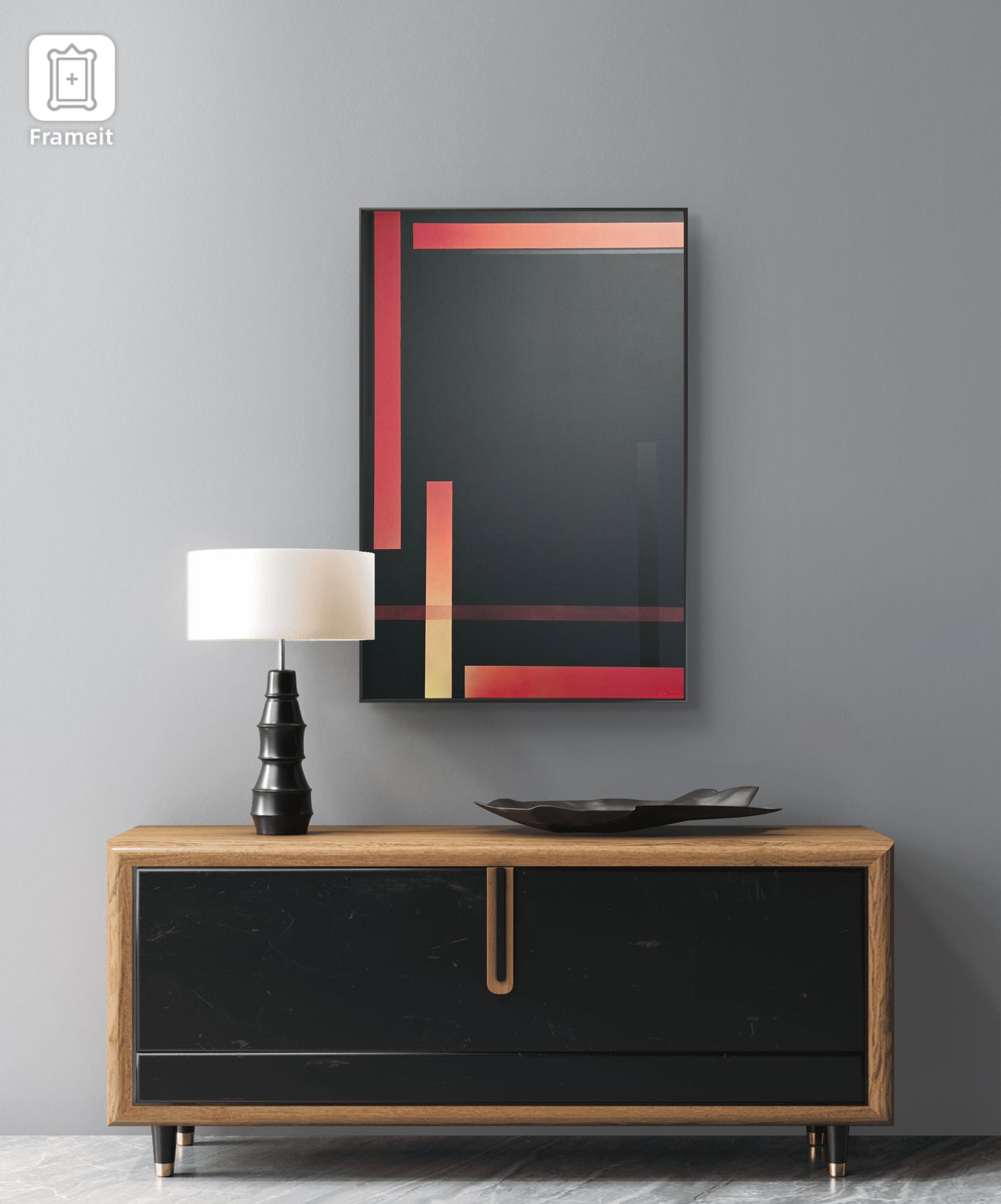 Modern interior with a black and red abstract painting, wooden sideboard, and lamp against a gray wall.